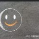 Kreidezeichnung auf Schiefertafel: Smiley als Symbol für Glück und Erfolg